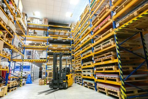 forklift in warehouse full of pallet jacks